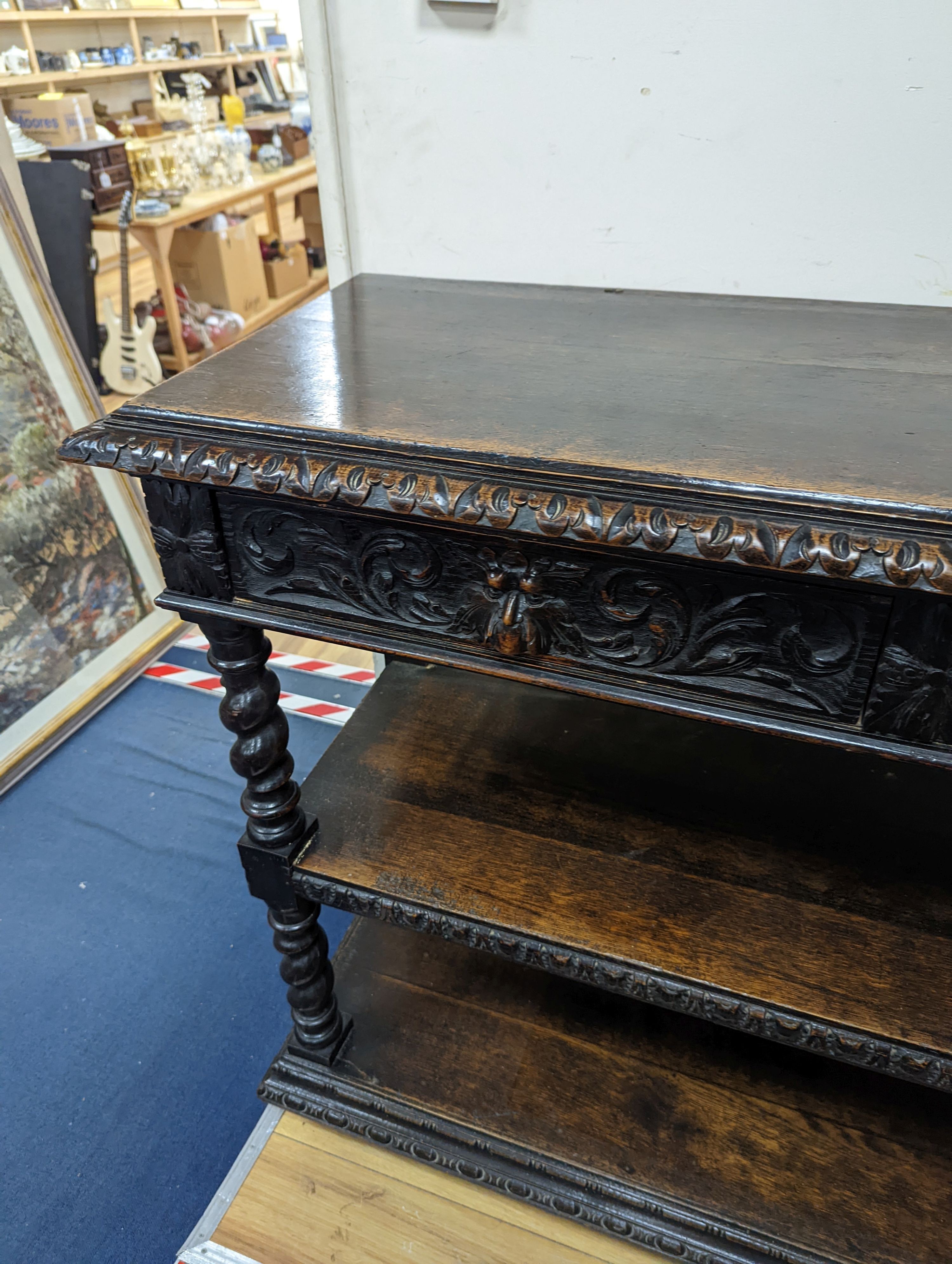 A 19th century Flemish carved oak three tier buffet, length 121cm, depth 46cm, height 98cm